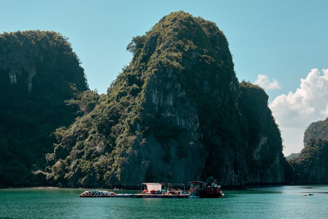 Traditional boat sailing through Ha Long Bay limestone karsts